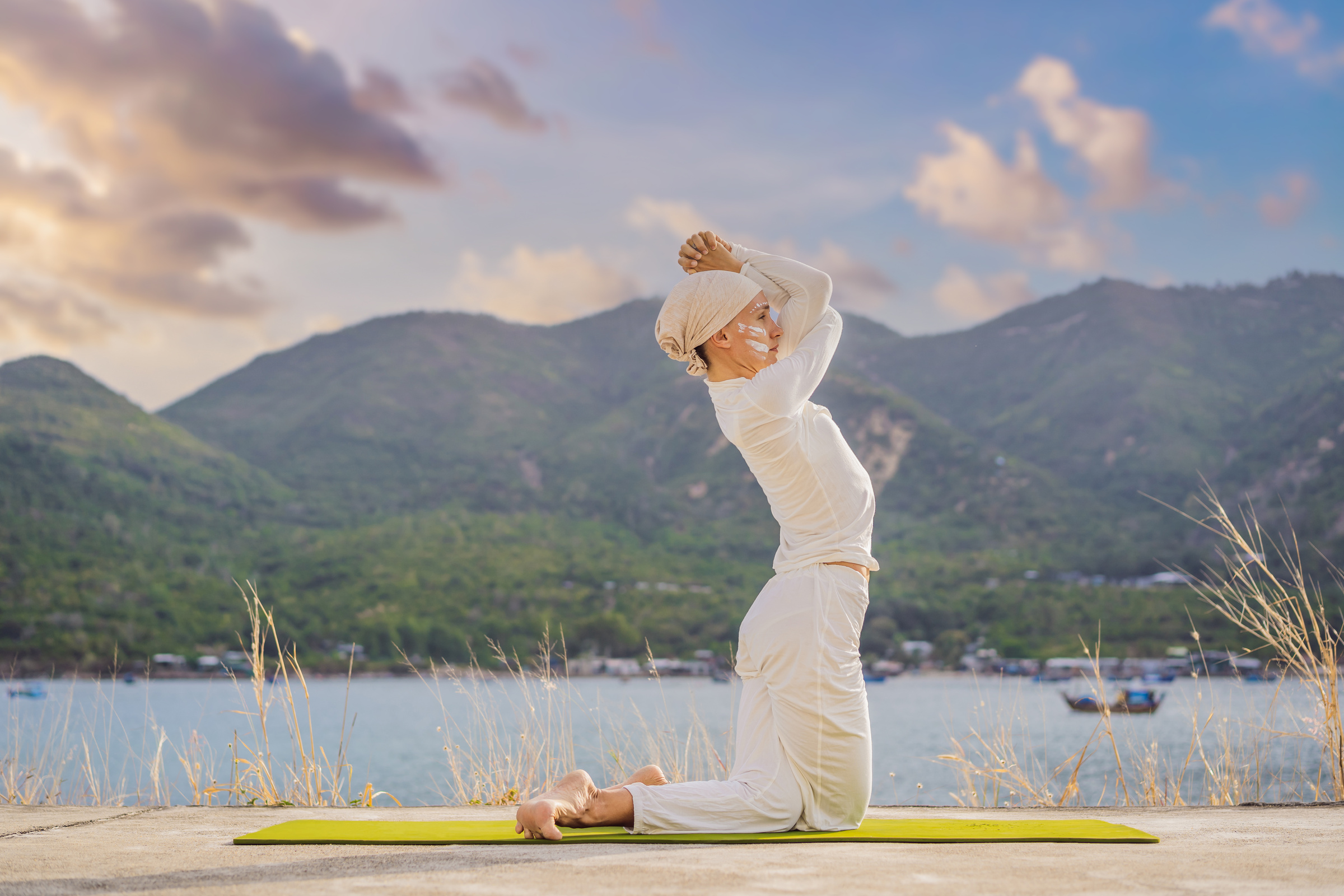 Kundalini Yoga Woman in White Clothes and Turban Practices Yoga Kundalini on the Background of the Sea, Mountains and Sunset. Fighting Face Painting of the Indians Shows Her Inner World. Visual Storytelling of a Woman Dedicated to Yoga